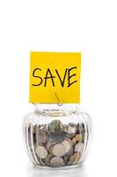 monedas en botella de vidrio sobre fondo blanco, ahorrando dinero para el futuro foto