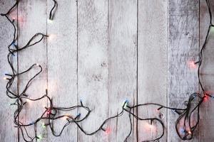 vista superior de las luces de navidad en el fondo de la mesa de madera foto