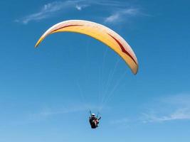 Paraglider flying in blue sky. photo