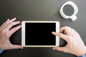 Top view of Male hands using Tablet, Cup of coffee on the desk. photo