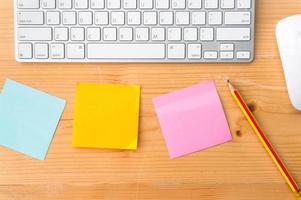 Top view workspace with colorful sticky notes ,pencil, keyboard and mouse on wooden table background. photo