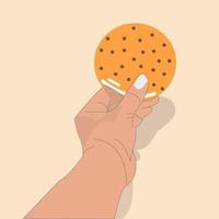 mano sostiene galletas con relleno vector