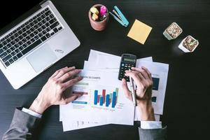 Top view of Businessman analyzing investment charts on the office desk. photo