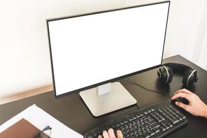 Close up of Male hands working on computer with white screen on the desk. photo