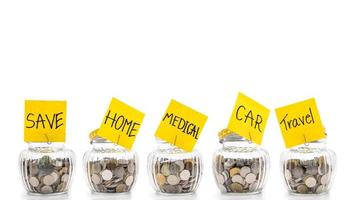 Coins in many glass bottles on white background, saving money concept photo