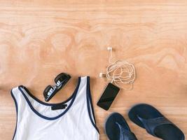 Top view of male summer accessories, clothes and gadgets on the wooden background. photo