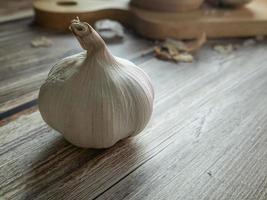 The garlic on wood table for food or cooking concept. photo