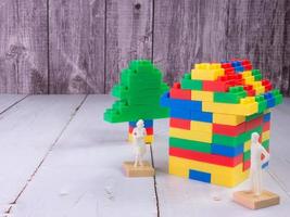 ladrillo de juguete multicolor en casa y figura blanca para niños o concepto de negocio de propiedad foto