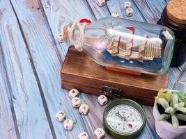 boat in  bottle on wood table for travel or transport concept photo