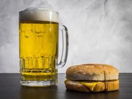 Hamburger with Glass of beer on the table over a grunge background. photo