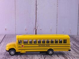 school bus on wood table for education concept photo