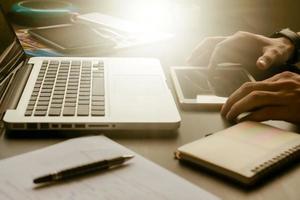 Close up of male hands using tablet on his office desk,toned with sunlight. photo