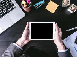 Top view of Businessman using tablet on the office desk. photo