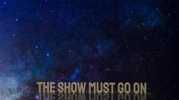 gold text the show must go on for present background photo