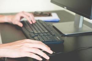 Close up of Male hands using desktop computer photo