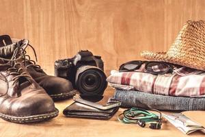 Male accessories, clothes and gadgets on the wooden table. Travel concept photo