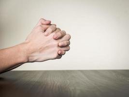 Hands folded together on the table, praying concept photo