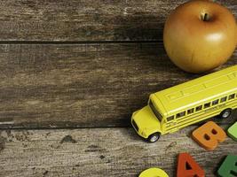 The school bus on wood table for back to school or education concept photo