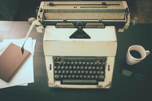 vieja máquina de escribir en el escritorio. tono antiguo foto