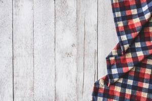 Top view of checkered cloth on wooden table background, Free space for text photo