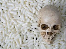 The skull  and white capsules image  for  sci or medical content. photo