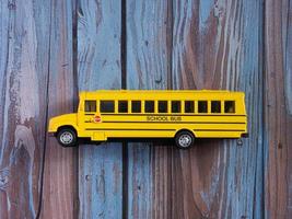 school bus on wood table for education or transportation concept photo