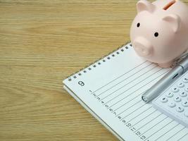 A piggy bank on wood table for  Finance or saving money business content. photo