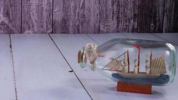 boat in  bottle on wood table for travel or transport concept photo