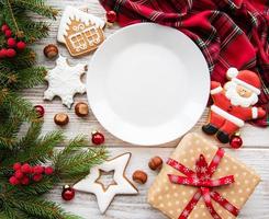 plato vacío con galletas de navidad y árbol de navidad foto