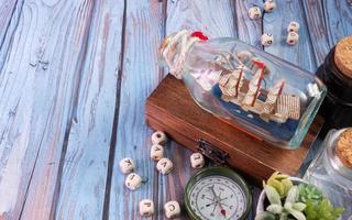 boat in  bottle on wood table for travel or transport concept photo