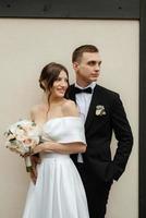 young couple bride and groom in a white short dress photo