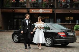 young couple bride and groom in a white short dress photo