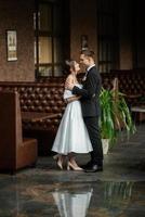 young couple bride and groom in a white short dress photo