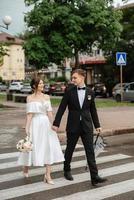 young couple bride and groom in a white short dress photo