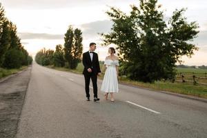 young couple bride and groom in a white short dress photo