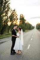 young couple bride and groom in a white short dress photo