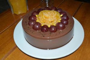 Selective Focus Of Yellow Flower From Oranges And Grapes On A Chocolate Pudding photo