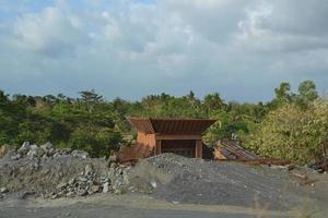 trituradora de piedra entre montones de arena y rocas foto