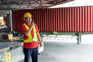 Foreman control loading containers box from cargo freight ship for import export, Foreman control industrial container cargo freight ship, Business import and export logistic concept. photo