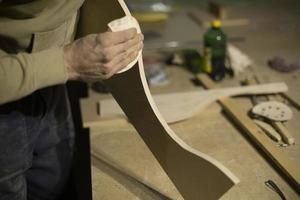 Carpenter grinds part out of wood. Board processing. Creation of furniture. photo