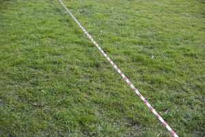 Fence ribbon over grass. Fencing of territory. photo