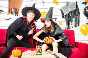 Happy Halloween party concept. Young man and woman wearing as vampires, witch or ghost celebrate the halloween festival photo