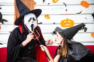 feliz concepto de fiesta de halloween. joven y mujer vestidos como vampiros, brujas o fantasmas celebran el festival de halloween foto