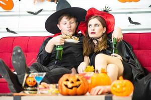 Happy Halloween party concept. Young man and woman wearing as vampires, witch or ghost celebrate the halloween festival photo