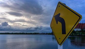 The signs on the left curve point towards the clouds. The sky after the sunset photo