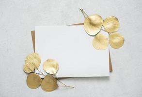 Mockup for a letter or a wedding invitation with gold leaves eucalyptus branches.