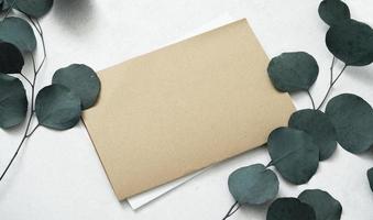 Mockup for a letter or a wedding invitation with leaves eucalyptus branches. photo