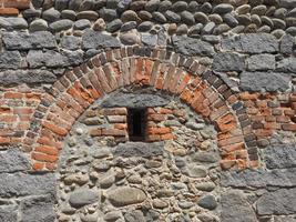 red brick arch in old wall background photo