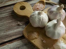 The garlic on wood table for food or cooking concept. photo