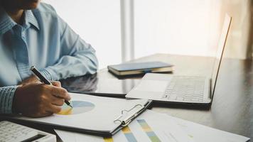 Professional businesswoman working on desk in office. Business woman hand analysis graph document financial on paperwork with chart data and marketing growth report on table. photo